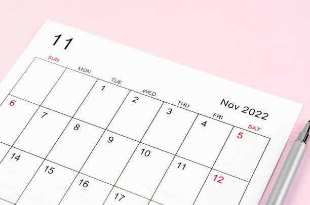 istock November 2022 calendar sheet with pen on pink background. 1360366254