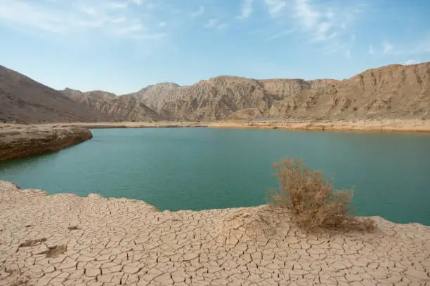 View of the Wadi Beeh Dam on a hot summer day in Ras Al Khaimah, United Arab Emirates. Oasis in the desert concept.