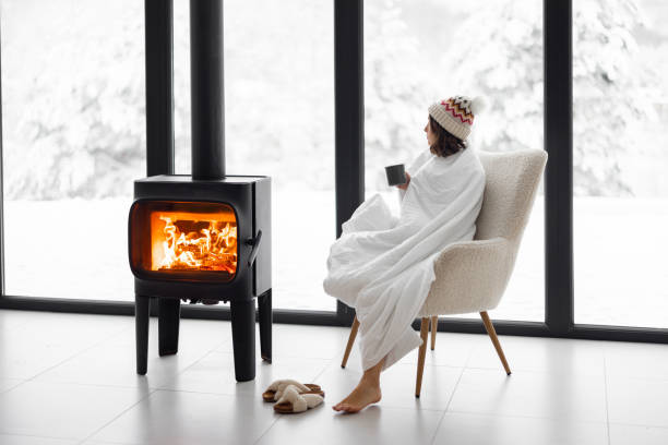istock Woman at home with burning fireplace during wintertime on nature 1360367397