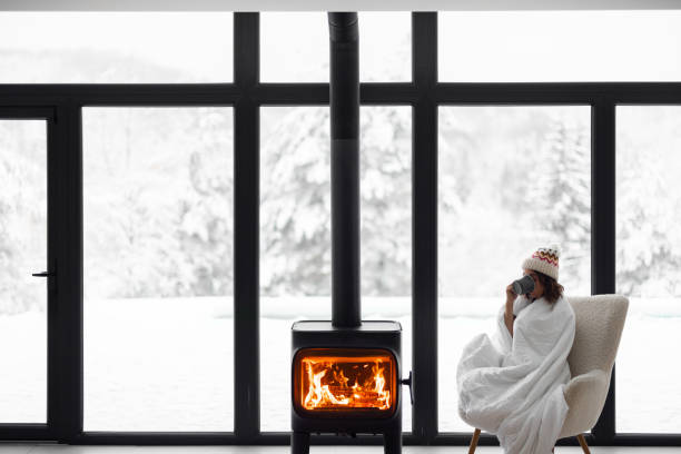 Woman at home with burning fireplace during wintertime on nature