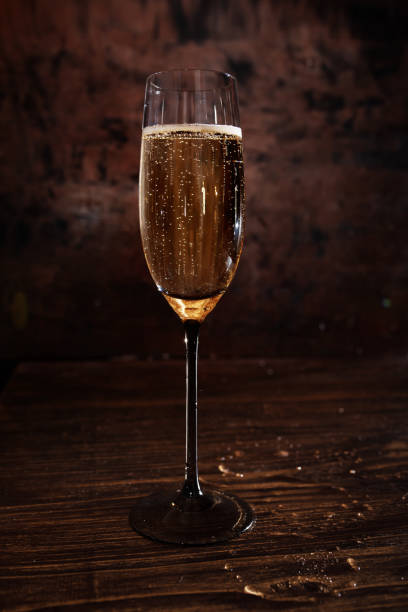 istock Glass with champagne on dark wood 1360368543