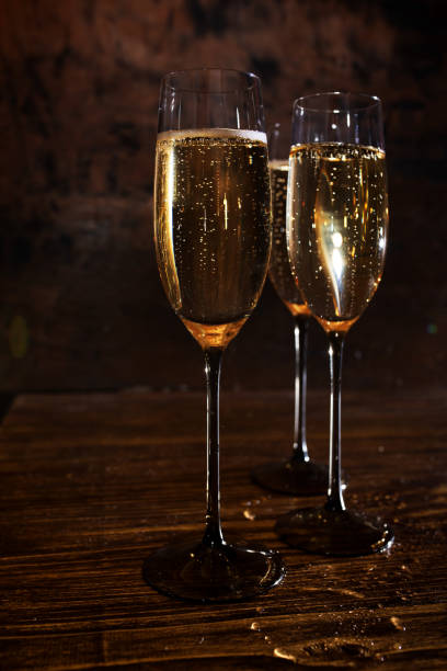istock Glasses with champagne on dark wood 1360368552