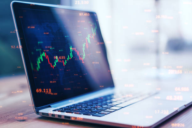 istock Close up of laptop with abstract candlestick forex graph and bid data numbers on blurry desktop background. Finance, technology, analytics and trade concept. Double exposure. 1360372657