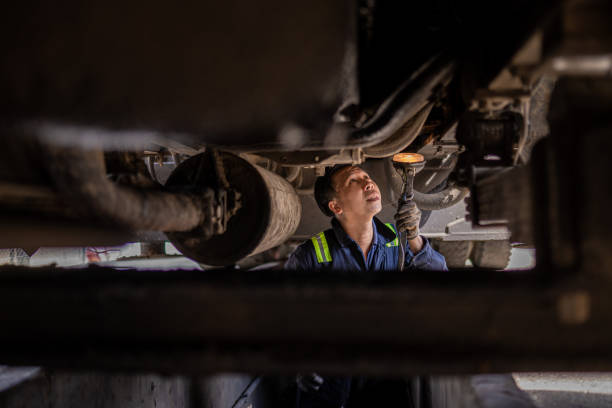 Asian Chinese mechanic checking truck chassis in the repair shop stock photo