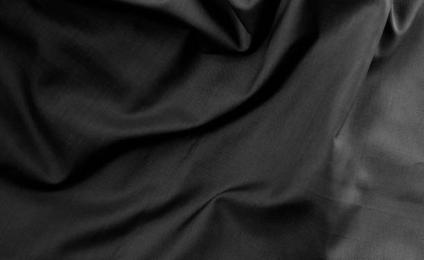 istock Dark moody twisted fabric with shallow depth of field for texture background 1360377169