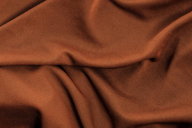 istock Luxurious golden color folded silk fabric for texture background 1360377333