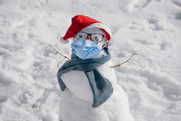istock Snowman wearing a medical face protection mask 1360380324