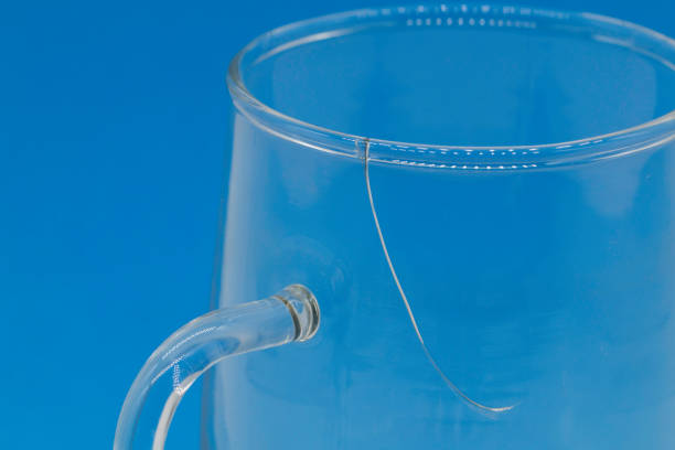 A close-up photo of a cracked tea cup, a blue background