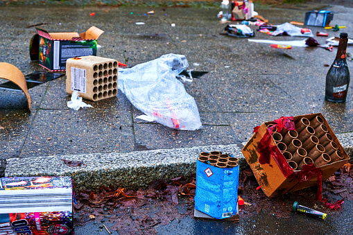 Berlin, Germany - January 1, 2021: Various remains of a New Year's Eve celebration on the sidewalk of a street.