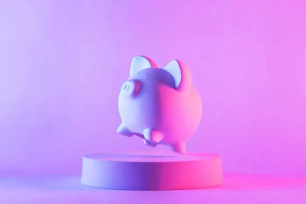 Photo of Studio close-up of piggy bank floating above a round podium