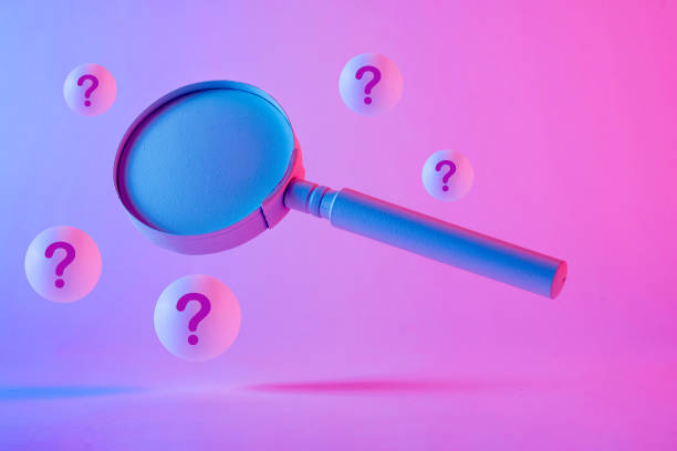 istock Close-up of a magnifying glass floating between question marks 1360381856