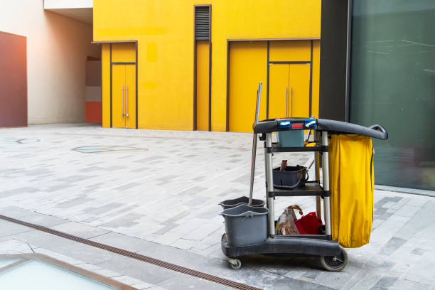 Cleaner cart in a public place with cleaning products: mop, buckets for cleaning the floor, broom scoop, household chemicals, household rags stock photo