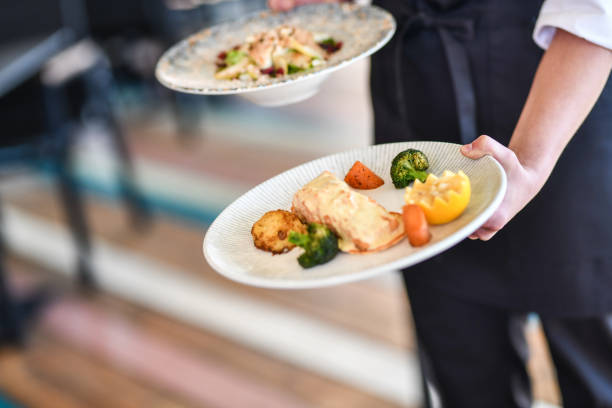 istock Fancy Dinner Appetizer Carried By Waitress In Restaurant 1360387943