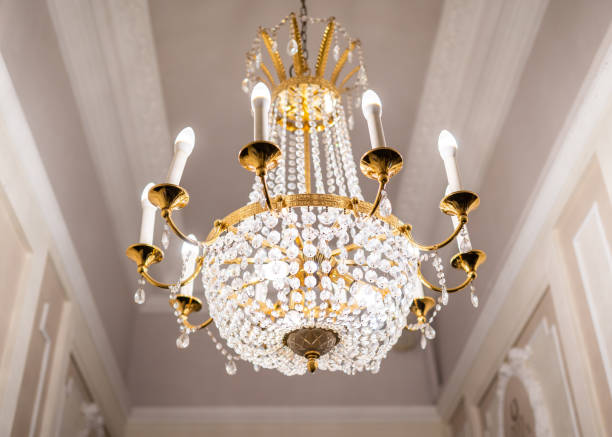 beautiful chandelier hanging from ceiling with classic gold plated fixtures - gold plated imagens e fotografias de stock