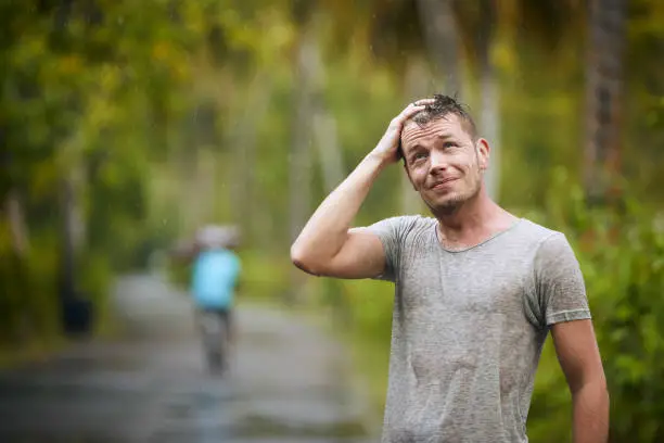 Photo of Man enjoying heavy rain in nature