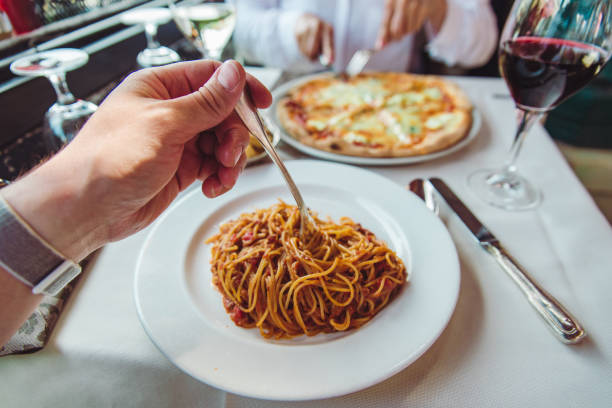 istock couple eating in restaurant pasta and pizza drinking wine 1360389146