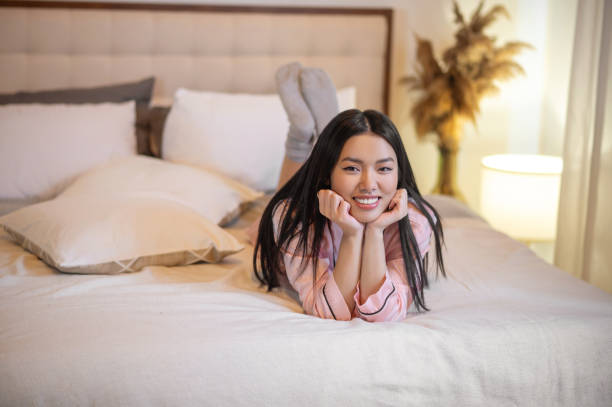 istock Woman lying on bed looking at camera 1360390625