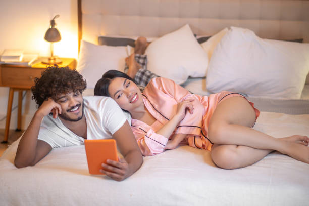 istock Woman leaning on man lying with tablet 1360390644