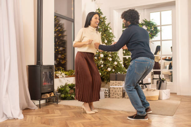 istock Woman watching man dancing near x-mas tree indoors 1360390707