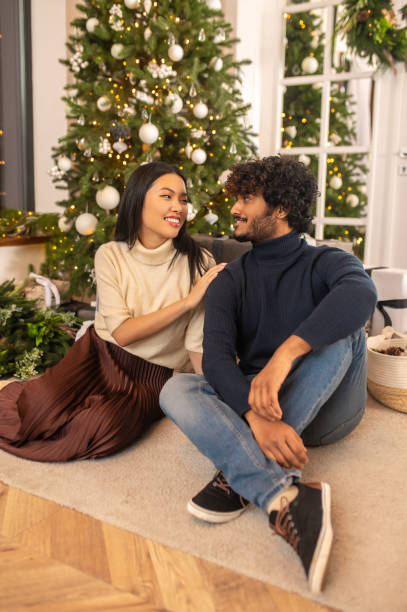 istock Woman touching man looking at each other sitting on floor 1360390712