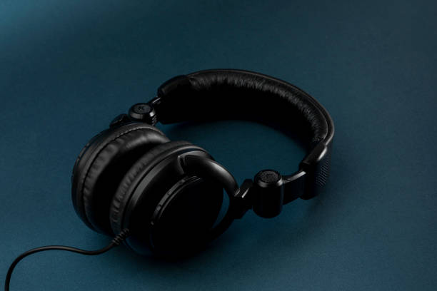 istock Black studio headphones with blue background and space for text 1360393099