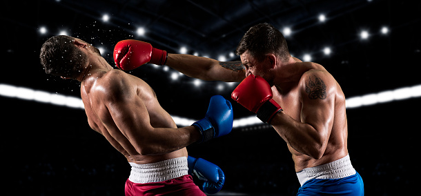 Asian fitness trainer support Caucasian sportsman doing boxing in gym. Attractive athlete people wear Muay Thai gloves workout and exercise by practice punching with competitor for health at stadium.