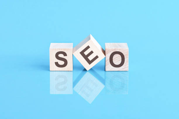 istock SEO - acronym from wooden blocks with letters, front view on blue background 1360394416
