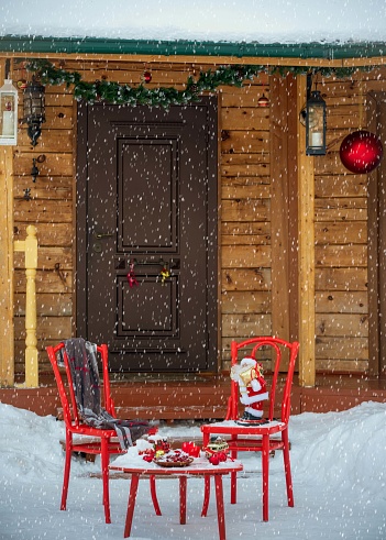 New Year's decorations with a red table and chairs in front of the house entrance.