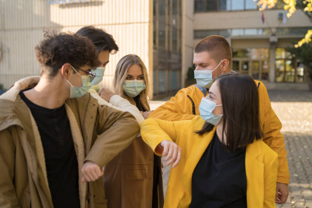 istock Young people friends bump their elbows instead of greeting with a hug - Avoid the spread of coronavirus, social distance and friendship concept - Focus on right girl eye 1360395502