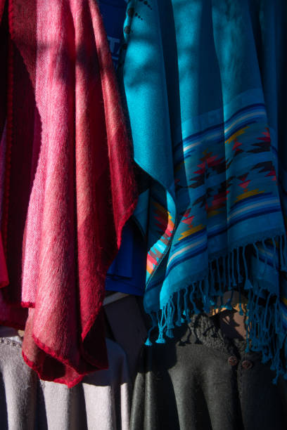 Colorful clothing hanging on adobe wall in New Mexico in southwestern USA.