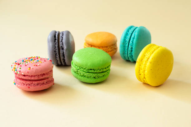 istock Sweet and colorful macarons on a yellow background, side view. 1360399990