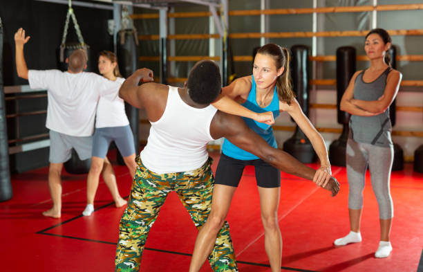 istock Men and women training self-protection moves in gym 1360402964
