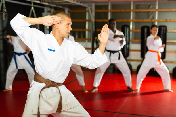 istock Adult man in kimono fighting stance at karate training 1360402986