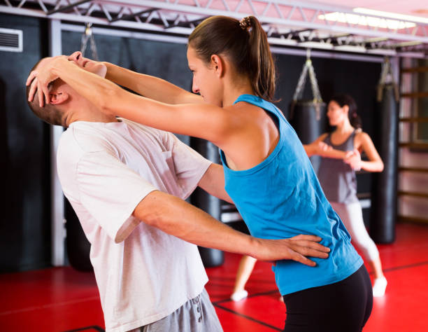 istock Woman practising eye gouging self-defensive move in gym 1360403102