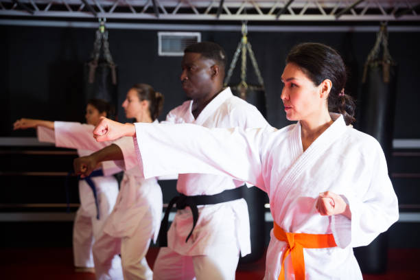 istock Adult people practicing taekwondo and warming up for training while standing barefoot 1360403123