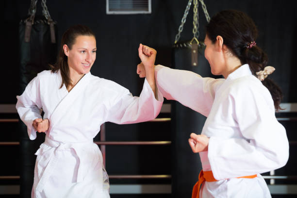 Women fighting during group karate training in gym