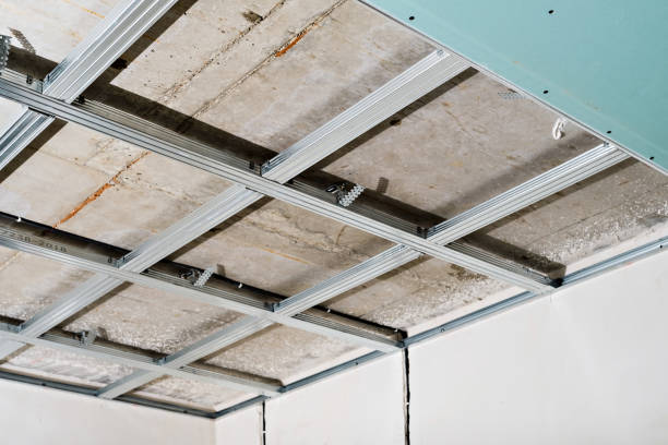 istock Metal frame on the ceiling for plasterboard installation in a commercial building, office or apartment. A simple and cheap way to renovate a room. Ceiling wiring of the electrical network. 1360403152