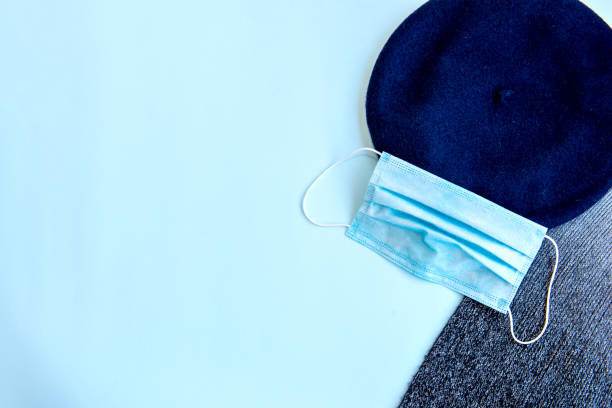 istock Beret, mask and scarf on blue background. Top view. 1360404334