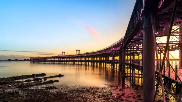 Photo of Panoramic view of the ore loading dock of the Rio Tinto mining company in Huelva, Andalusia, Spain. Sunset at the Muelle del Tinto