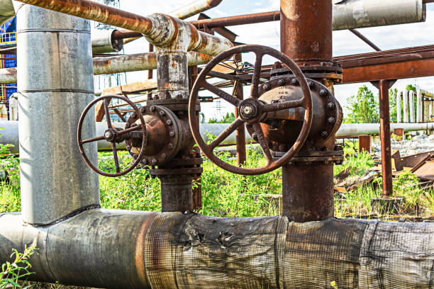 viejas válvulas oxidadas son pestillos en la tubería de una planta química abandonada - old station natural gas russia fotografías e imágenes de stock