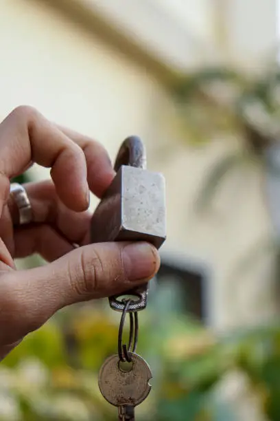 Photo of Lock with keys holding in handin garden