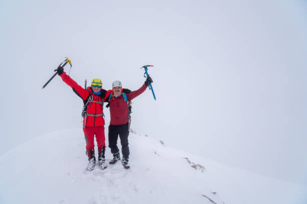 성공적인 노인 등산팀은 안개가 낀 날씨에 겨울에 높은 고도의 산의 절정에 얼음 도끼를 들고 미소짓고 있습니다. - turkey extreme terrain snow nature 뉴스 사진 이미지