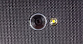Mobile phone, single smartphone camera lens with an LED flash light object macro, detail, extreme closeup, nobody. Modern phone cam up close, recording video, taking photos, spying abstract concept