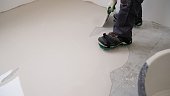 Spreading self leveling compound with trowel. Self-leveling epoxy. Leveling with a mixture of cement floors. Leveling liquid floors with a trowel