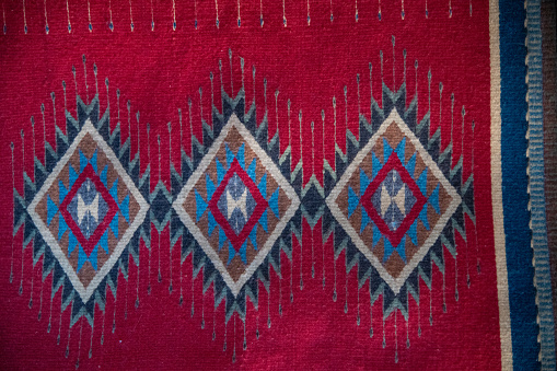 Colorful rug or clothing hanging on adobe wall in New Mexico in southwestern USA.