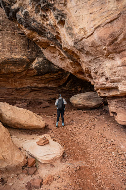 istock Hiker Checking Out The Trail Turning Into A Cave 1360423936