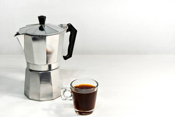 istock Italian coffee maker with espresso coffee on white wooden table. 1360431322
