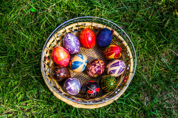 istock Defocus multicolored easter eggs. Decorated pysanka and krashanka. Wooden Basket With Easter Eggs In The Green Grass. Close-up. Top view. Handmade decor. Out of focus 1360432507