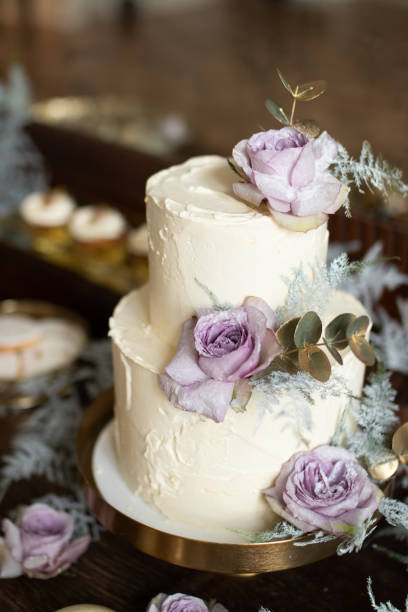 istock White wedding cake with purple flowers on the table 1360433486