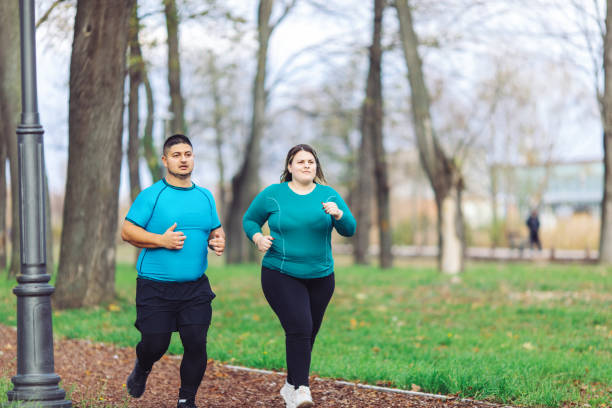 istock People with overweight problem running in city park 1360433595